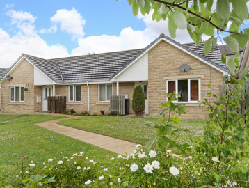 Flowers and green gardens to the front of bungalows