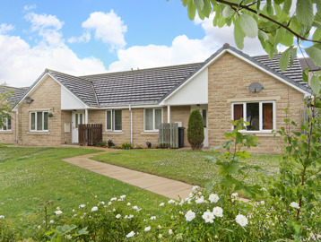 Flowers and green gardens to the front of bungalows