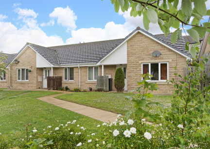 Flowers and green gardens to the front of bungalows