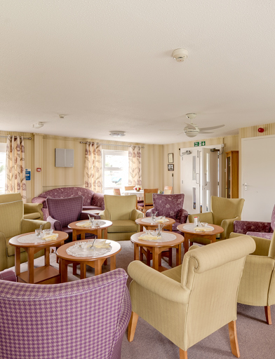 Mix of armchairs and coffee tables in the residents' lounge 