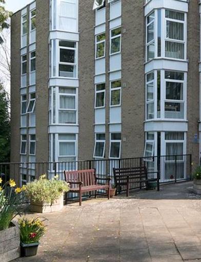 Large patio area with plants, flowers, trees and seating in the communal area