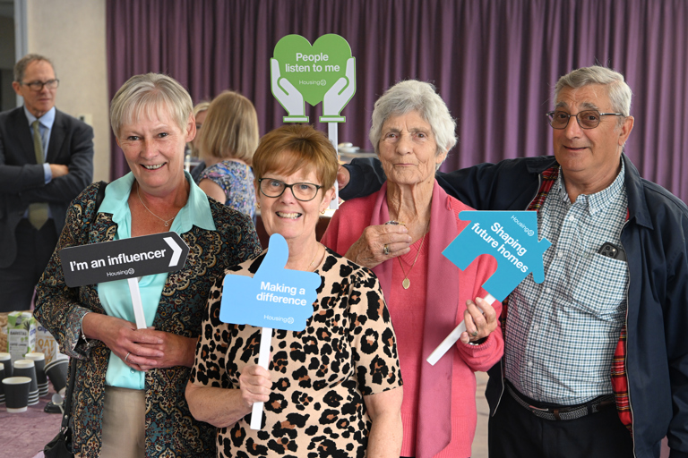Four residents posing with influencer signs, smiling and having fun