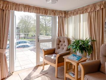 Two armchairs and a table in the lounge of an apartment