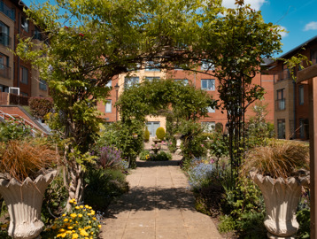 View through a series of archways in the garden covered in climbing plants