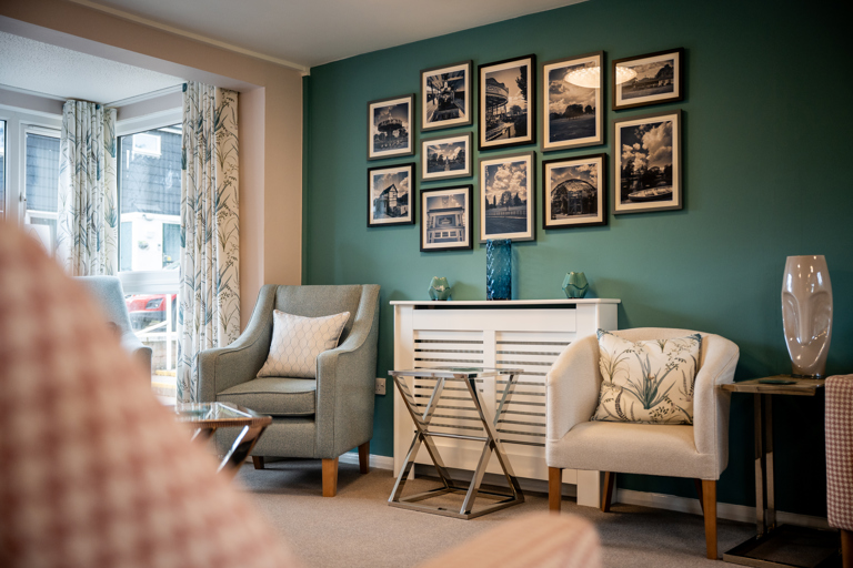 Chairs in a modern communal lounge with artwork on the walls
