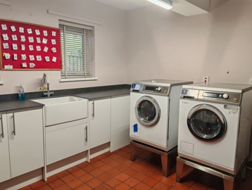 A laundry room with two washing machines, raised up for easier access.