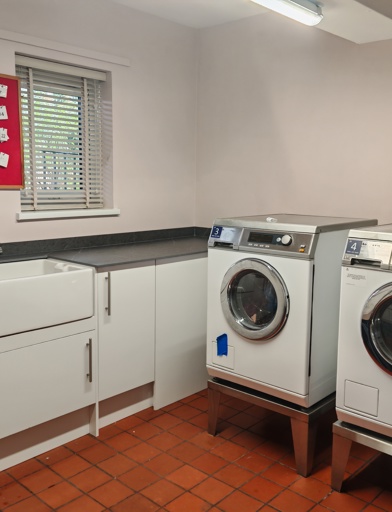 A laundry room with two washing machines, raised up for easier access. 