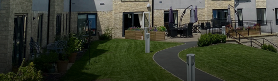 The front cover of the developing together brochure. The exterior of a building fronted by a path and garden
