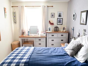 Bedroom in a resident's apartment with a double bed, storage and vanity table