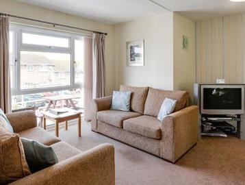 Living room area in a resident's apartment with sofas and TV
