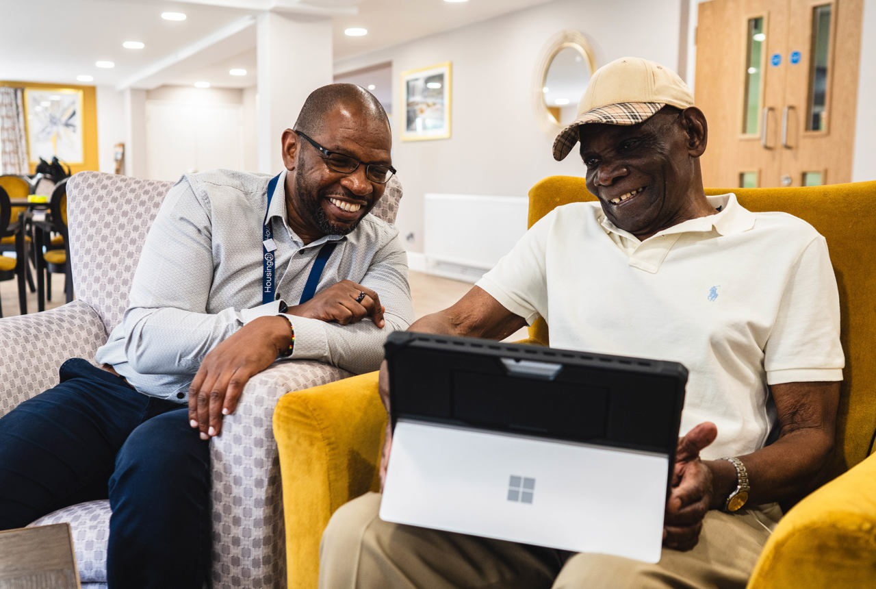 Resident and employee sitting down using a laptop