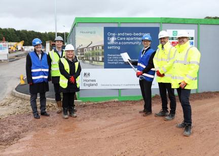 A group of people in high-vis vests and hard helmets at the ground breaking ceremony