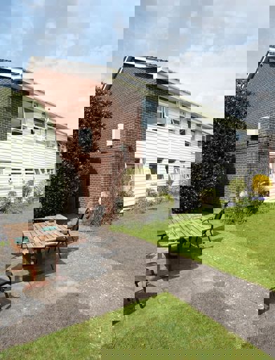 A selection of garden chairs around a table in the garden area on a sunny day 