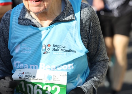 Judith's official Brighton half marathon photo - wearing a blue running bib while running