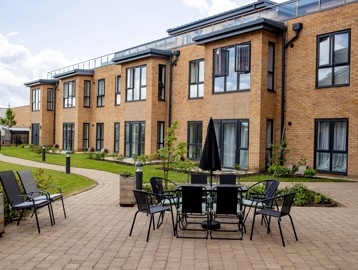 A photo of a large patio area in the gardens of Poppy Gardens with table and chairs