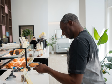 Resident Stephen picking up a cookie from a local cafe