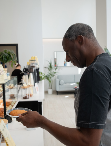 Resident Stephen picking up a cookie from a local cafe 