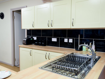 Communal kitchen with sink, toaster and stylish worktops and tiling