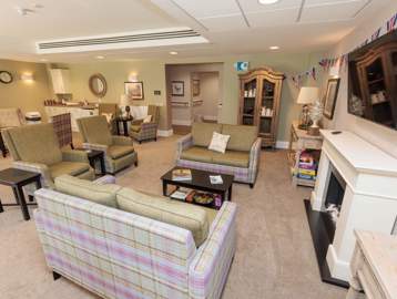 An image showing inside Bowland View's communal lounge with sofa's, chairs and coffee tables 