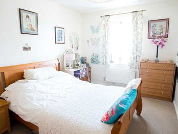 Double bedroom with wooden furnishings and bright, natural lighting