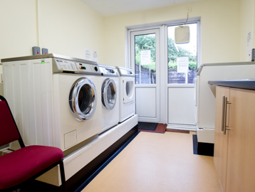 Communal laundry room with door leading to outside
