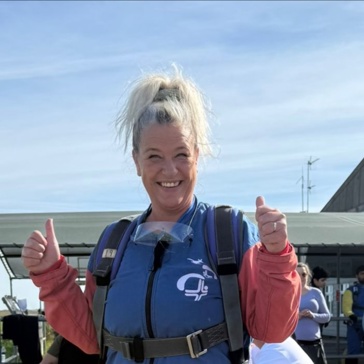 A woman gives a thumbs up ahead of taking part in a skydive