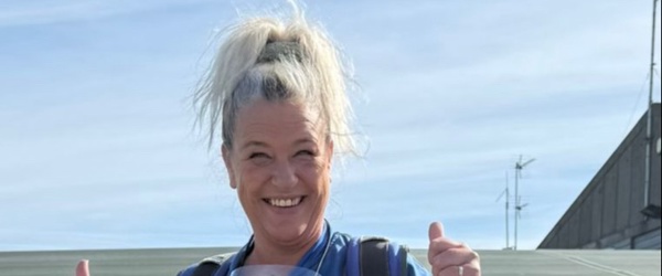 A woman gives a thumbs up ahead of taking part in a skydive