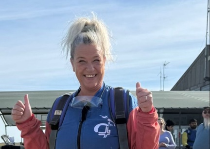 A woman gives a thumbs up ahead of taking part in a skydive