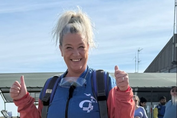 A woman gives a thumbs up ahead of taking part in a skydive