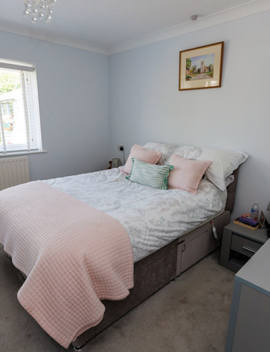 A double bed in the centre of the room with a window to one wall, a wardrobe to the foot of the bed and a chest of doors by the entrance 