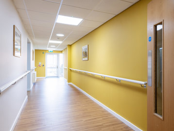 A yellow hallway with railing