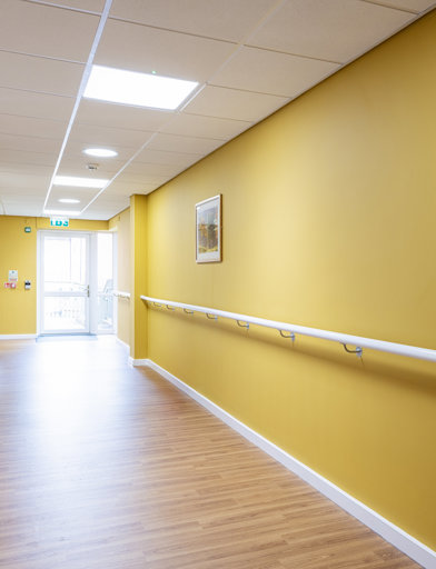 A yellow hallway with railing
