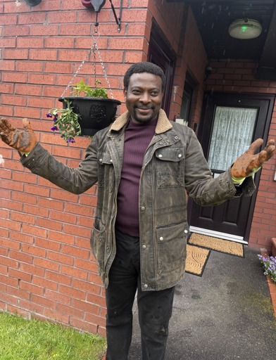 Festus The Local Manager at Sydney Jones Court wearing gardening gloves 