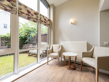 A small seating area in front of a large window overlooking the garden