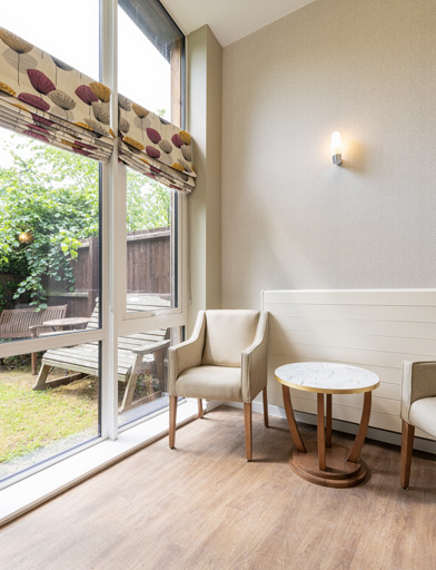 A small seating area in front of a large window overlooking the garden 