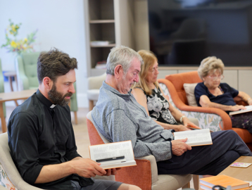 Residents Reading With Priest at Lea Springs