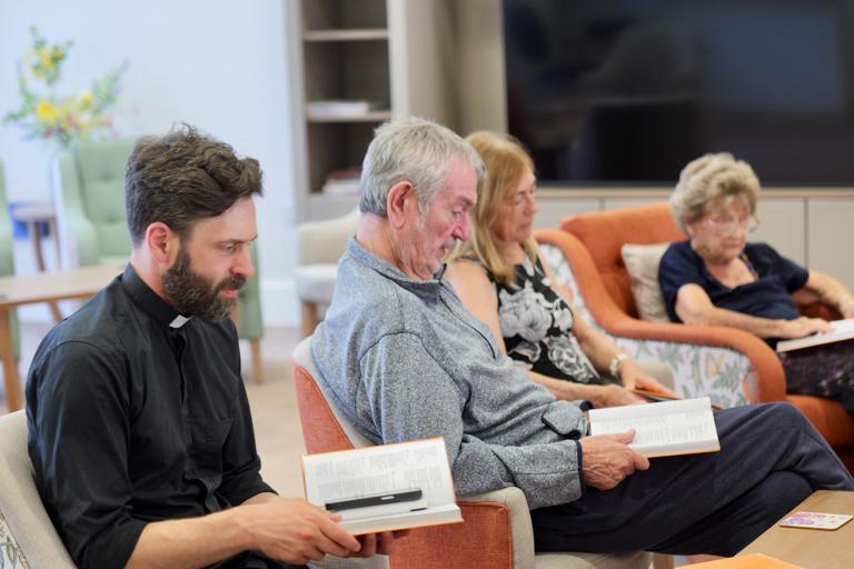 Residents Reading With Priest at Lea Springs