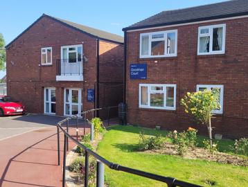 A photo of the outside area of Goodman Court with car parking spaces and garden area