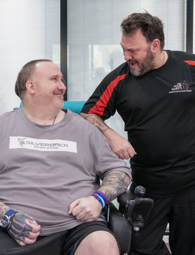 Chris, a Housing 21 resident, and his physio, Marc, smile at each other 