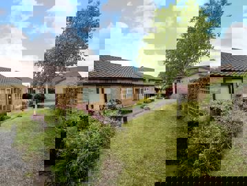 A exterior side view image of Cory Road featuring grass and trees