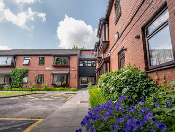 William Griffiths Court External purple flowers and the front doors to the scheme