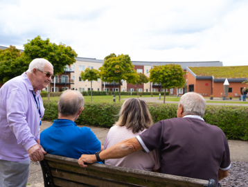 Residents sat on a bench in the communal garden talking 
