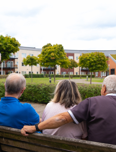 Residents sat on a bench in the communal garden talking