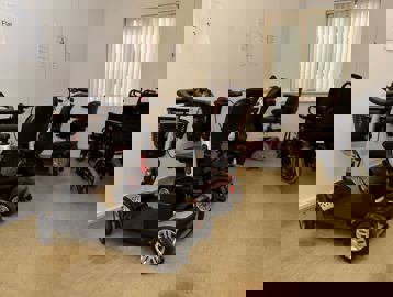 Electric scooters and wheelchairs in a buggy store room