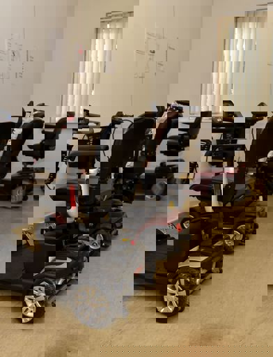 Electric scooters and wheelchairs in a buggy store room