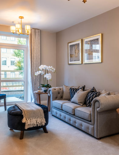 Inside the show home living area with large sofa and coffee table 