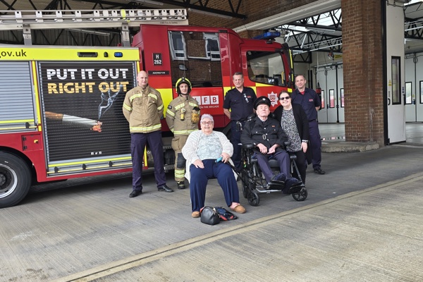 Employees at Sutton Fire Station with Veronica and John, and their daughter Claire by a fire engine.