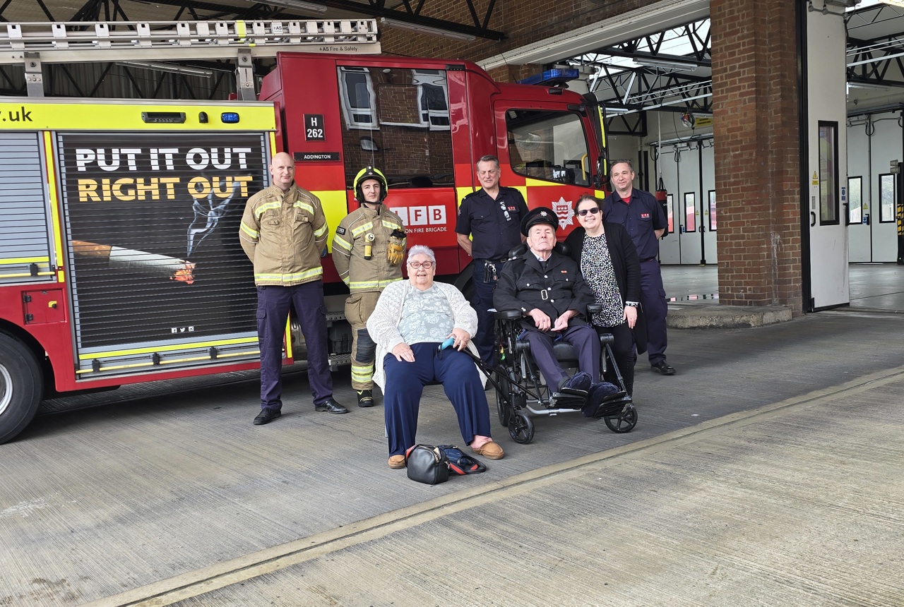 Employees at Sutton Fire Station with Veronica and John, and their daughter Claire by a fire engine.