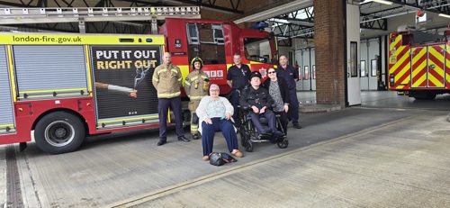 Employees at Sutton Fire Station with Veronica and John, and their daughter Claire by a fire engine.