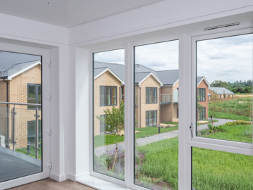 Inside the show home looking through large first floor windows into the communal gardens